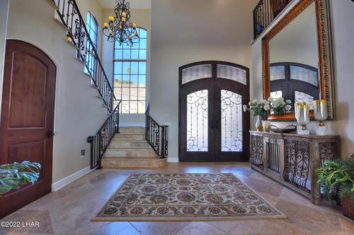 a foyer with a wooden door and a rug at Splash Landing! Dock, Pool & Hot Tub , Riverfront House & Guest in Cienega Springs