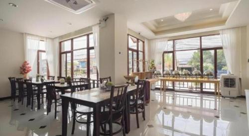 a dining room with tables and chairs and windows at The La-Ngu Boutique in Satun