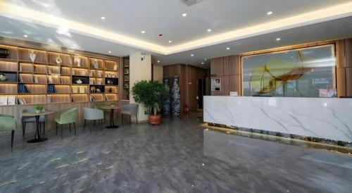 a lobby with a bar and tables and shelves at GreenTree Inn Express Hebei Tangshan Guyan District Xinguang Road in Tangshan