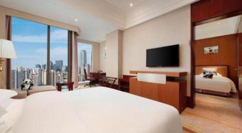 a hotel room with a large bed and a television at Balan International Hotel in Dujiangyan