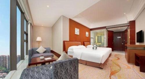 a large hotel room with a bed and a couch at Balan International Hotel in Dujiangyan