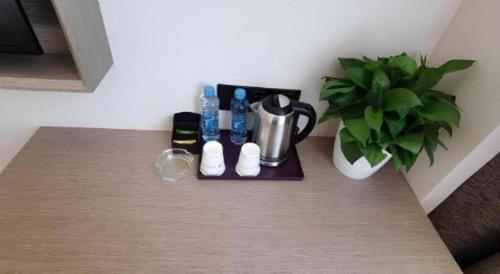 a tray with bottles and a potted plant on a table at GreenTree Inn Express Fuzhou Linchuan District Gandong Auto City in Fuzhou