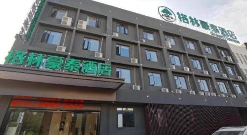 a building with a sign on the side of it at GreenTree Inn Express Fuzhou Linchuan District Gandong Auto City in Fuzhou