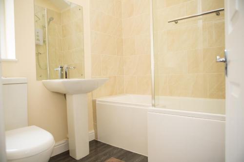 uma casa de banho com um lavatório, uma banheira e um WC. em Plover Cottage em Huddersfield