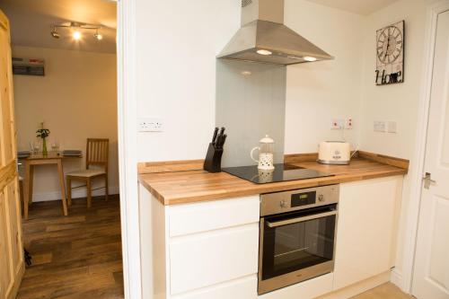 a kitchen with a stove and a counter top at Plover Cottage in Huddersfield