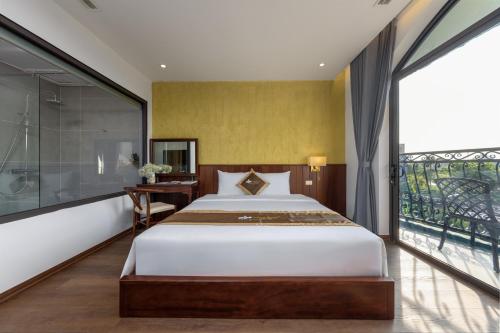 a bedroom with a large bed and a balcony at Tam Coc Orchid Hotel & Spa in Ninh Binh