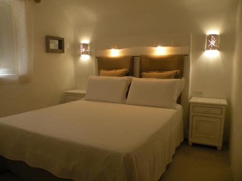 a bedroom with a bed with white sheets and pillows at Trullo Picchiagiuda in Ostuni