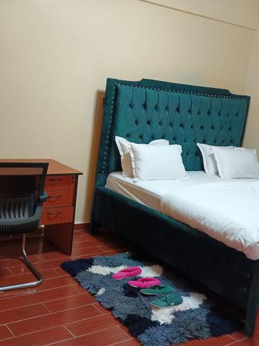 a bedroom with a bed and a desk and a rug at Luxurious 2bedroom furnished apartment in Nairobi