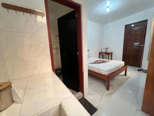 a bedroom with a bed and a bathroom with a shower at Baron Tourist Inn in El Nido