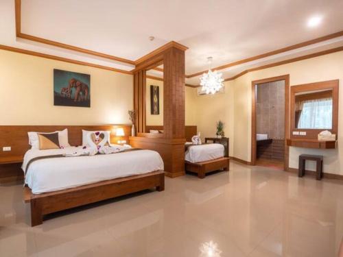 a large bedroom with two beds and a bathroom at Baan Sailom Hotel Phuket - Sha Extra Plus in Karon Beach
