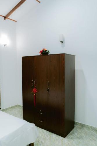 a wooden cabinet in a room with a bed at Grand Line Homestay in Kamburugamuwa