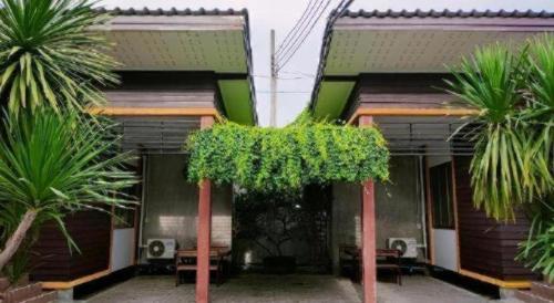 a house with palm trees in front of it at Kidthuengpark in Si Racha