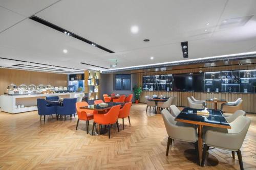 a restaurant with tables and chairs and a cafeteria at Echarm Hotel Changsha Wuyi Square Xiangya Affiliated 1st Provincial Maternity and Child in Changsha