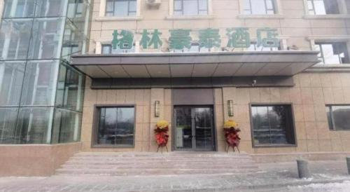 a building with flowers on the front of it at Green Tree Inn Urumqi San'gong Metro Station Exit in Ürümqi