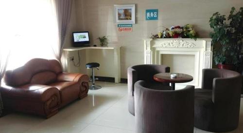 a living room with leather furniture and a fireplace at Green Tree Inn Urumqi San'gong Metro Station Exit in Ürümqi