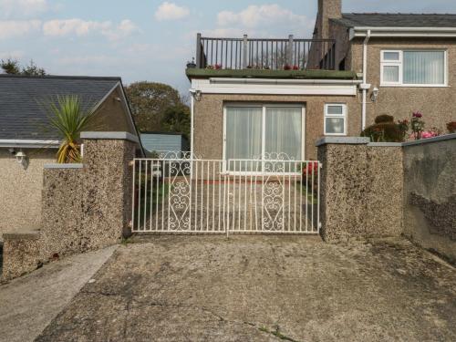 a gate to a house with a balcony at Maesawel Studio in Harlech