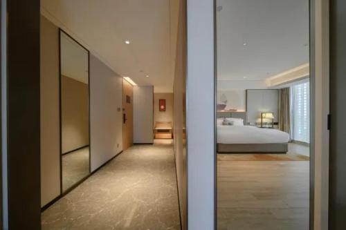 a bedroom with a bed and a large mirror at Echeng Hotel Nanning the Mixc Convention in Nanning