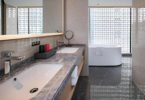 a bathroom with two sinks and a large mirror at Echeng Hotel Nanning the Mixc Convention in Nanning