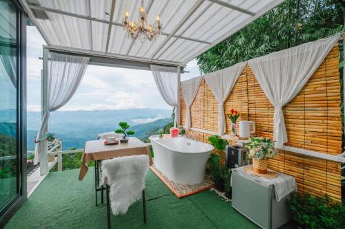 a bathroom with a tub on a balcony with a view at Naraview at phuchifa in Thoeng