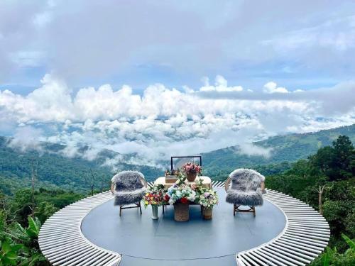 a table with two chairs on top of a mountain at Naraview at phuchifa in Thoeng