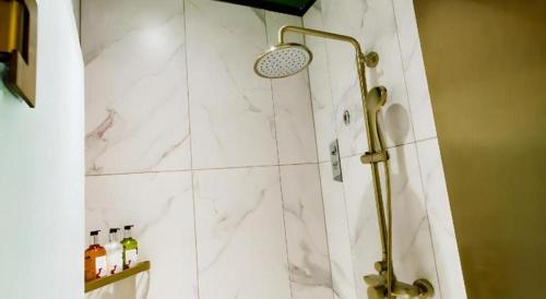 a shower in a bathroom with a marble wall at Borrman Hotel Jining High-tech Huangtun in Jining