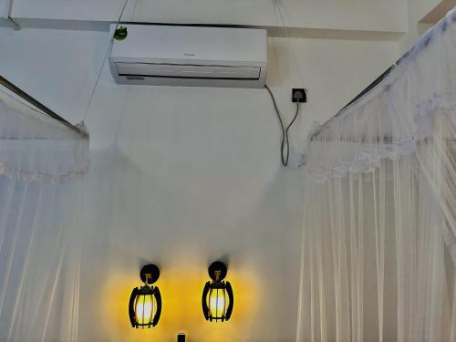 two lights in a room with a white curtain at Shining Green View in Ella