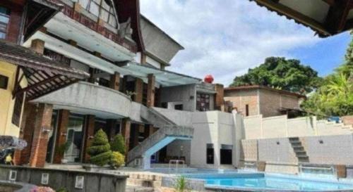 a house with a swimming pool in front of it at Sapadia Hotel Parapat in Parapat