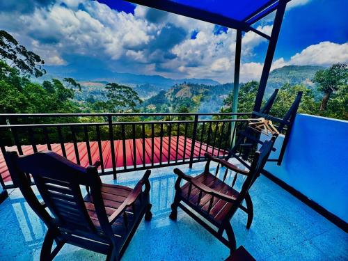 two chairs on a balcony with a view of the mountains at Shining Green View in Ella