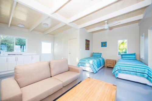 a living room with a couch and a bed at Frederick and Ngamata's Beach House in Rarotonga