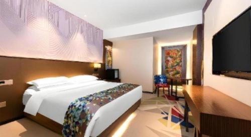a bedroom with a large bed and a flat screen tv at Borrman Hotel Wuhan Hankou Railway Station Metro Station in Wuhan