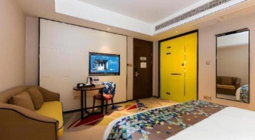 a bedroom with a bed and a yellow door at Borrman Hotel Wuhan Hankou Railway Station Metro Station in Wuhan