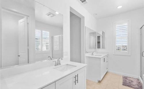 a white bathroom with a sink and a mirror at Rois Yucaipa in Yucaipa