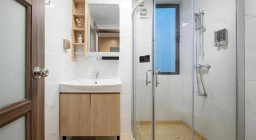 a bathroom with a sink and a shower at Poltton International Service Apartment Shanwei Urban District High-speed Railway Station in Shanwei