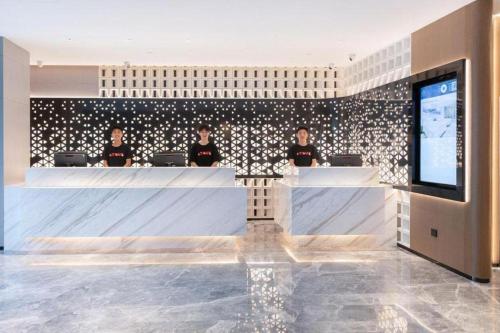 a group of people sitting at a desk in a lobby at Atour Hotel Jinan Tangyan Century Avenue in Jinan