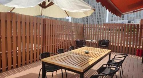 a wooden table and chairs with umbrellas on a deck at Atour Hotel Jinan Tangyan Century Avenue in Jinan