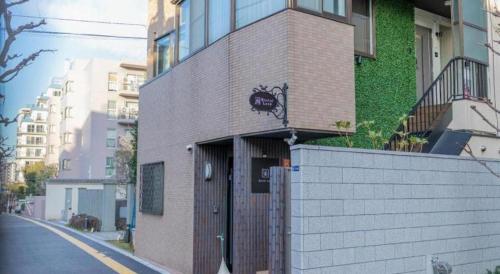 a brick building with a door on the side of a street at HOSTEL LUND I -Oimachi- in Tokyo