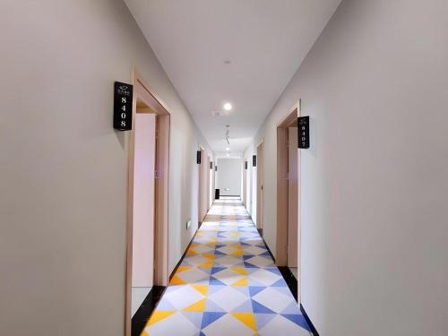 a hallway with a colorful floor in a building at Shell Hotel Wuxi Huishan District Chang'an Town in Wuxi