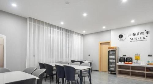 a dining room with tables and chairs and a counter at GreenTree Inn Express Qingdao Jiaodong International Airport in Qingdao