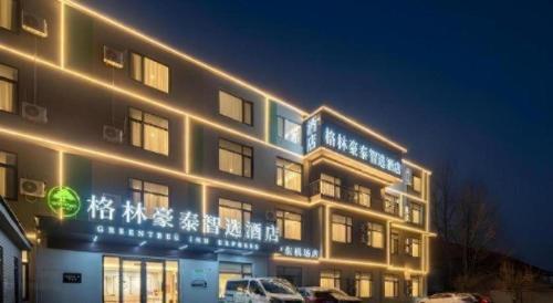 a building with lights on it at night at GreenTree Inn Express Qingdao Jiaodong International Airport in Qingdao