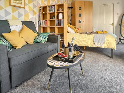 una sala de estar con un sofá y una mesa en Derriford Muse, en Crown Hill