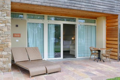 a patio with a table and chairs and sliding glass doors at Le Ali Del Frassino in Peschiera del Garda