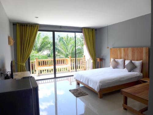 ein Schlafzimmer mit einem Bett und einem Balkon in der Unterkunft Le Pes Villas in Khanom