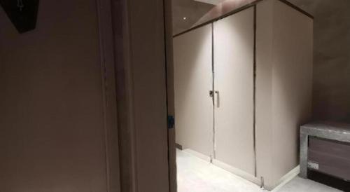 a large white cabinet in a room at Echarm Hotel Wuhan Gaotie Jianshe 2nd Road Metro Exit in Wuhan