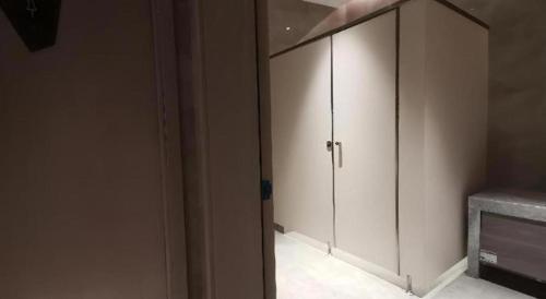 a white cabinet in a room with a fireplace at Echarm Hotel Wuhan Gaotie Jianshe 2nd Road Metro Exit in Wuhan