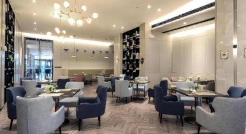 a restaurant with tables and chairs and a wine cellar at Echarm Hotel Wuhan Gaotie Jianshe 2nd Road Metro Exit in Wuhan