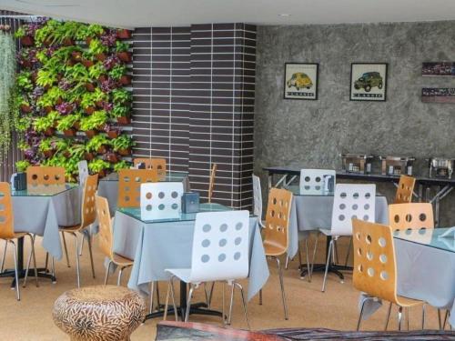 a dining room with blue tables and chairs at The Grace Residence in Surin