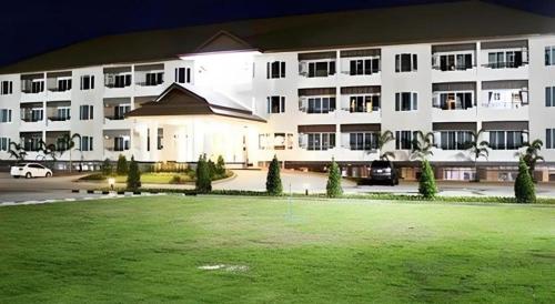 a large white building with a lawn in front of it at Siamtara Palace Hotel in Maha Sarakham