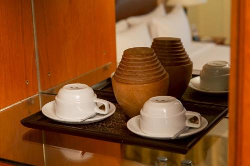 a shelf with three cups and plates on it at CS Pattani Hotel in Ban Ru Sa Mi Lae