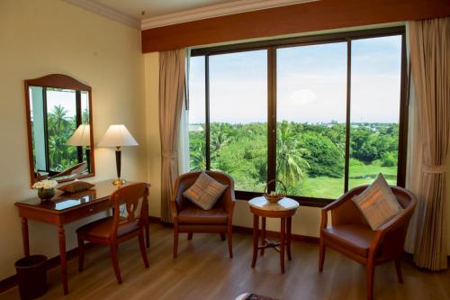 a room with a desk and chairs and a large window at CS Pattani Hotel in Ban Ru Sa Mi Lae