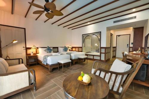 a hotel room with a bed and a table and chairs at My BanLao Hotel in Luang Prabang